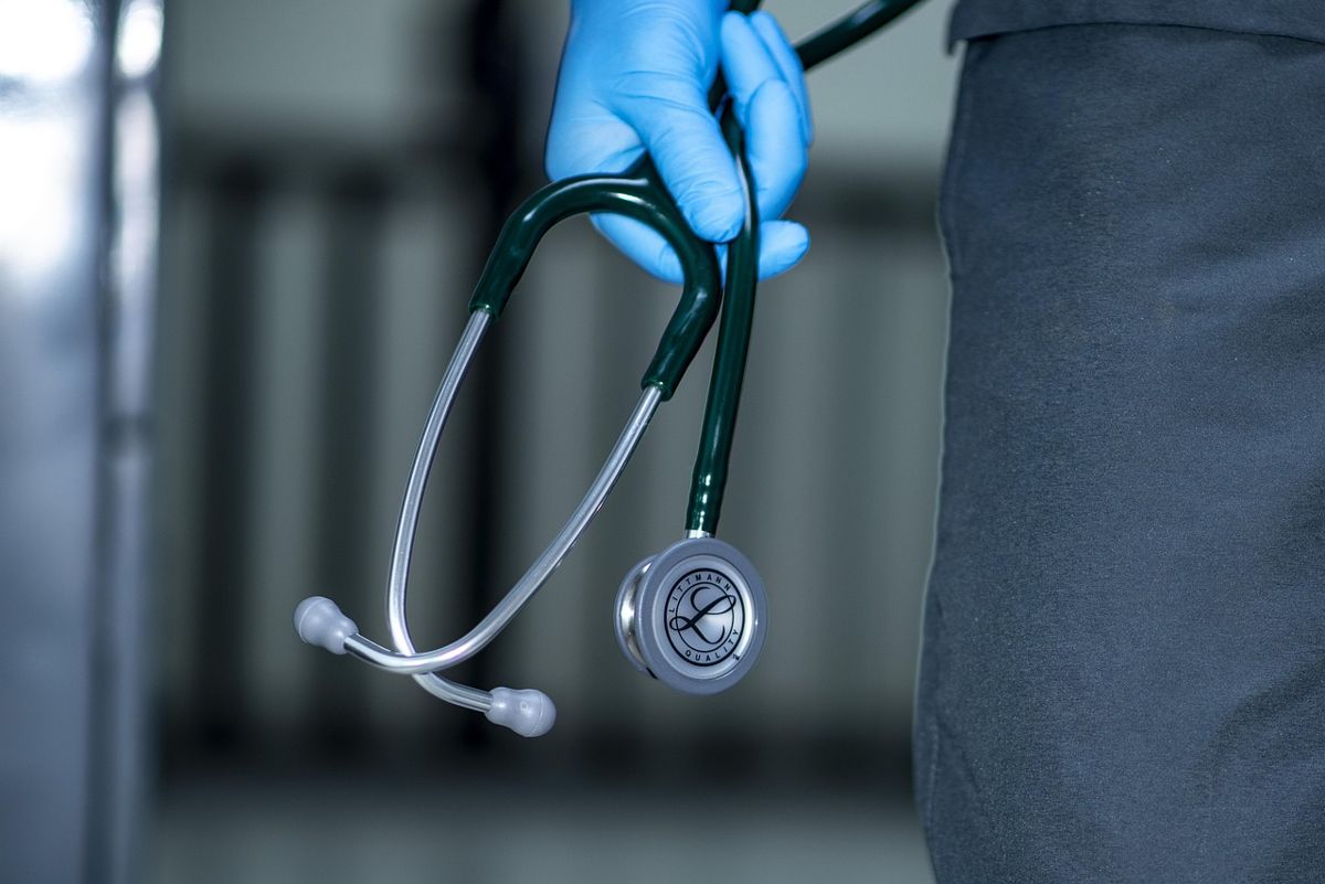 Gloved hand holding a stethoscope