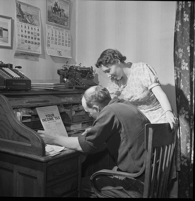A New Mexico couple at a roll-top desk working out their own income tax return in February 1943