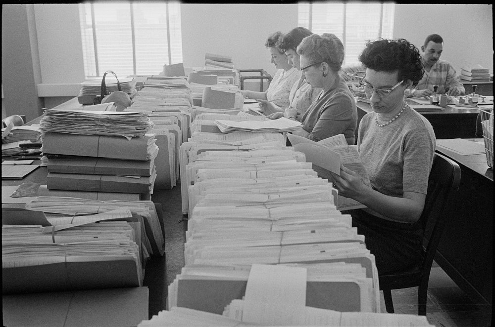 Rows of IRS employees checking stacks of income tax returns, Baltimore, 1960