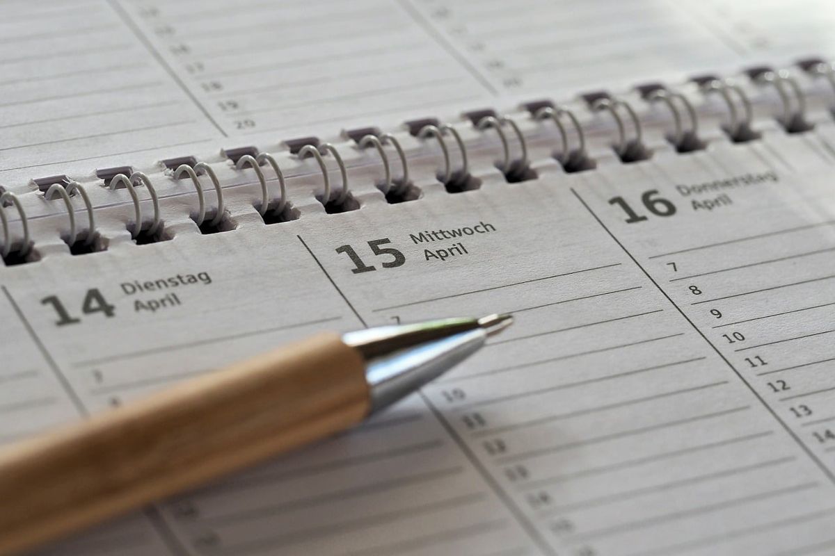 Desk planner open to April 15 with a pen resting on it